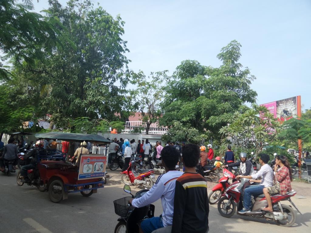 មនុស្ស​ឈរចាំតាមដានហេតុការណ៍នៅ​មុខ​ក្លឹបហ៊ីបហប់